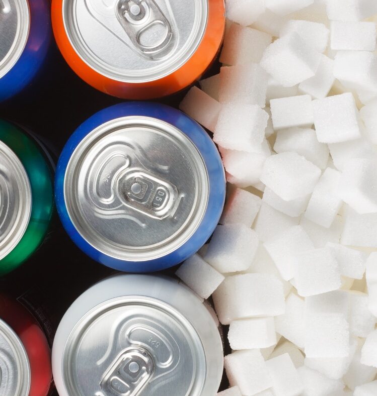 Various cans of sugar standing next to a pile of sugar cubes