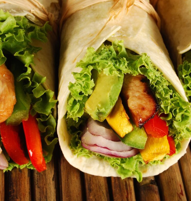 Burritos filled with vegetables and meat