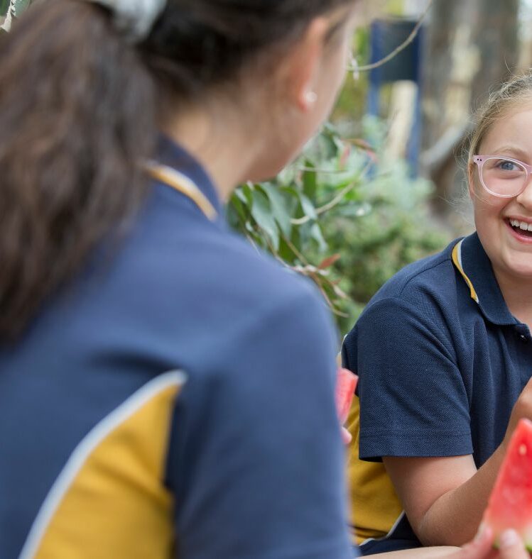 Two school children eating watermelon