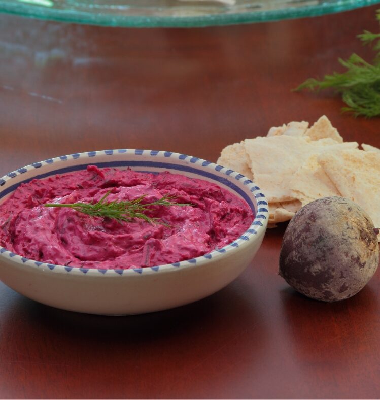 a bowl of beetroot, horseradish and dill dip next to a whole beetroot