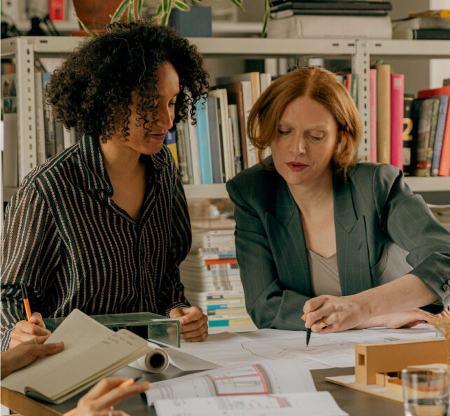 Two people sitting at a table discussing paperwork